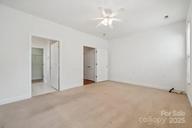 an empty room with a ceiling fan and a window