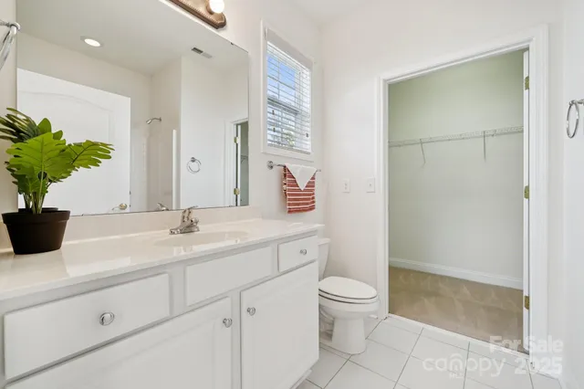 a bathroom with a granite countertop sink a toilet and a mirror