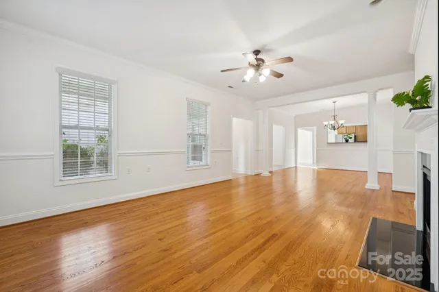 a view of an empty room with window and wooden floor
