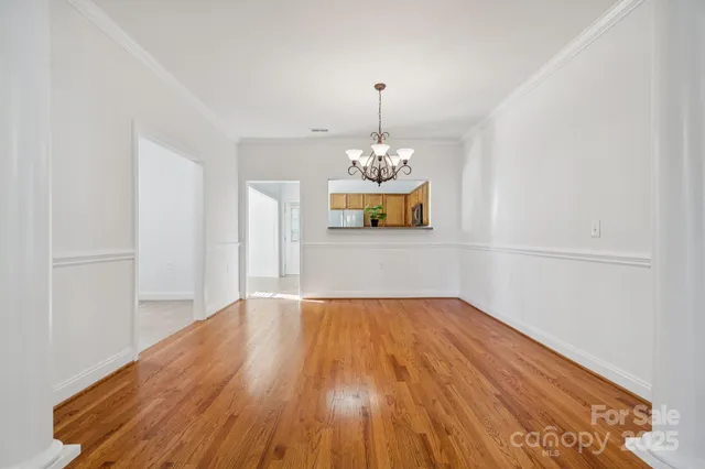 a view of a room with wooden floor and chandelier