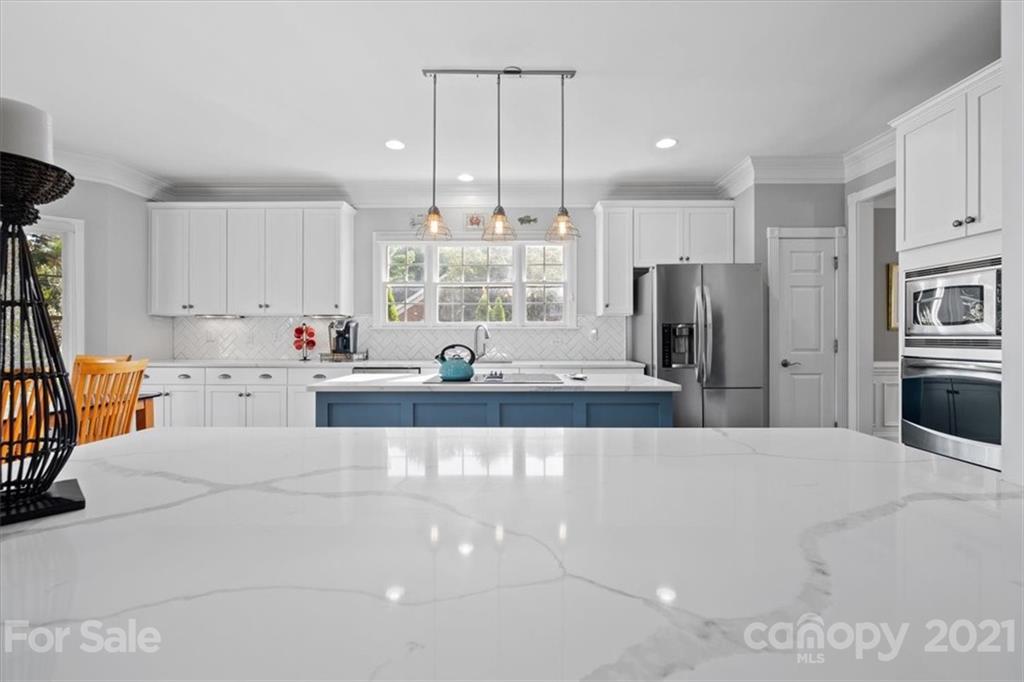 1743 Bentgrass Lane Tega Cay, SC 29708 - Photo 14 of 47 a large white kitchen with a large window and stainless steel appliances