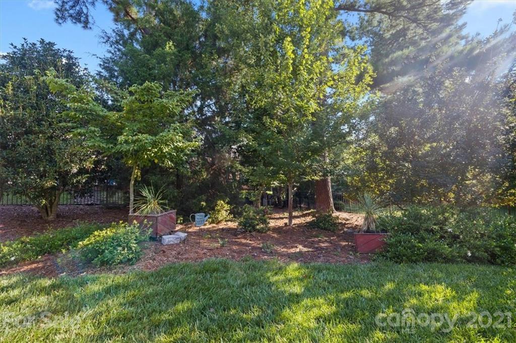 1743 Bentgrass Lane Tega Cay, SC 29708 - Photo 36 of 47 a backyard of a house with table and chairs under an umbrella