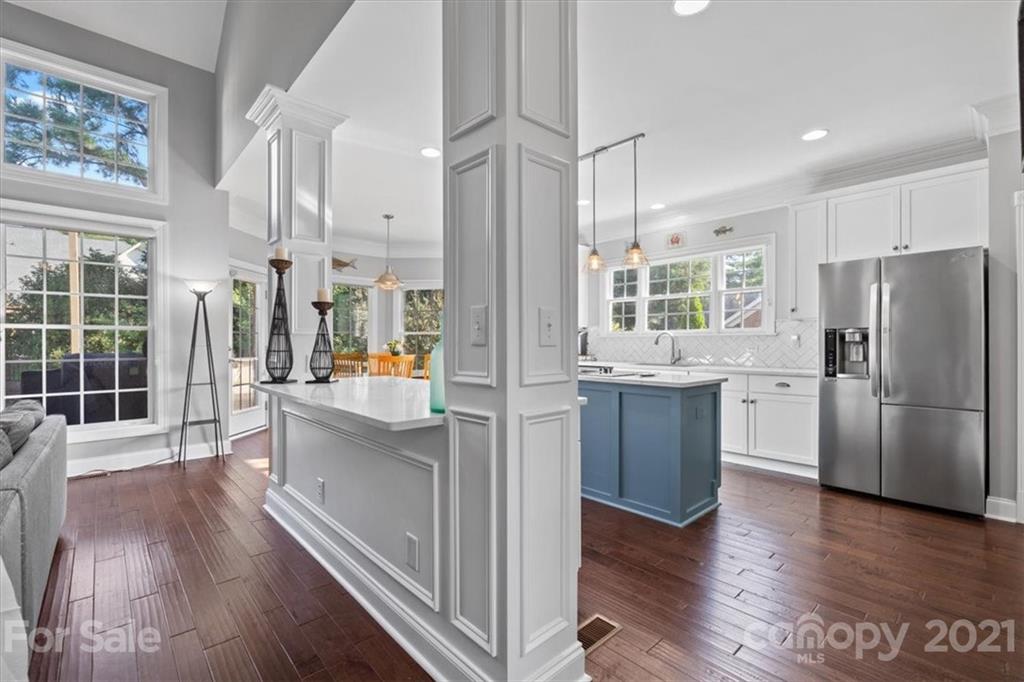 1743 Bentgrass Lane Tega Cay, SC 29708 - Photo 6 of 47 a kitchen with stainless steel appliances a refrigerator a sink dishwasher a stove and white countertops with wooden floor