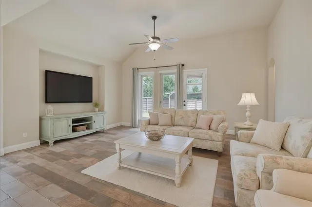 a living room with furniture a fireplace and a flat screen tv