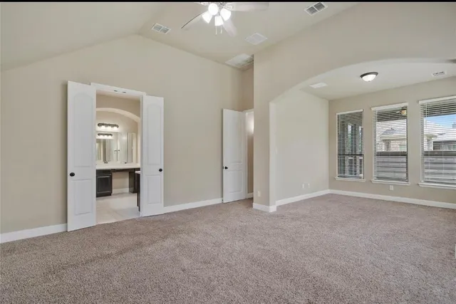 an empty room with windows and bathroom view