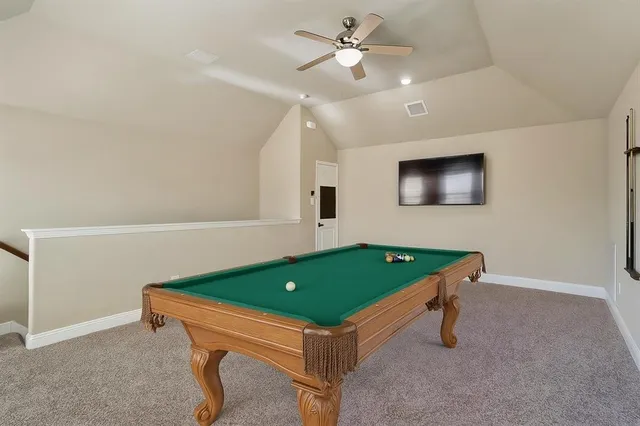 a room with pool table and a ceiling fan