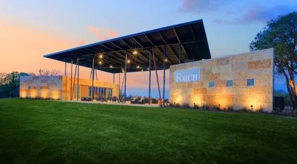 a backyard of a house with plants and large tree