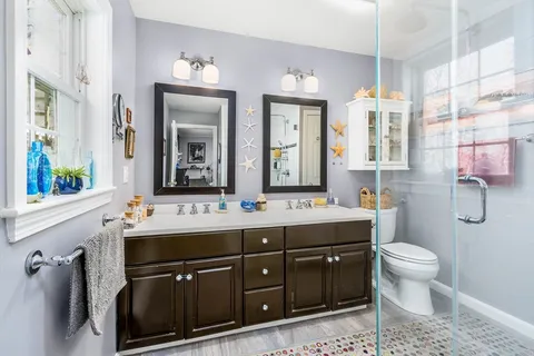 a bathroom with a sink a toilet and a mirror