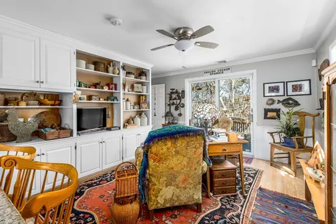 a view of a dining room with furniture a kitchen and chandelier