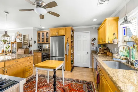a kitchen with stainless steel appliances granite countertop a sink a stove and a refrigerator