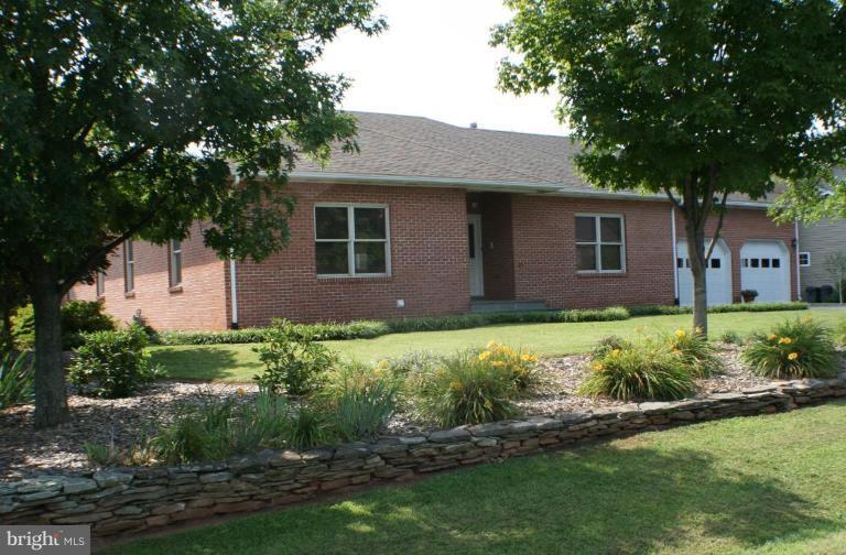 8124 Stone Ridge Drive Frederick, MD 21702 - Photo 1 of 28 a brick house with a yard plants and large tree