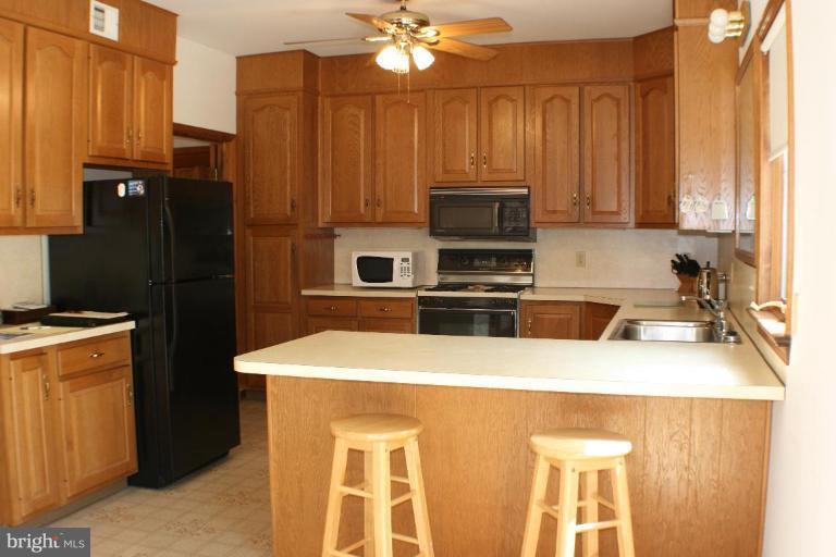 8124 Stone Ridge Drive Frederick, MD 21702 - Photo 3 of 28 a kitchen with stainless steel appliances granite countertop a refrigerator a stove top oven a sink and dishwasher