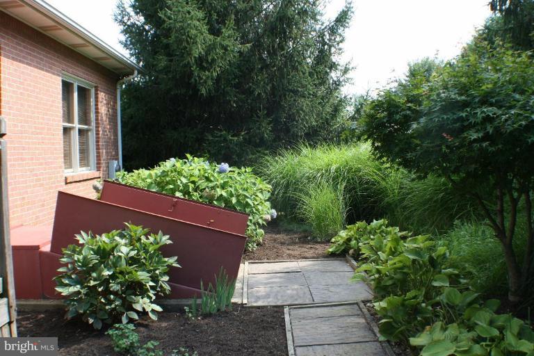 8124 Stone Ridge Drive Frederick, MD 21702 - Photo 21 of 28 a view of a house with a small yard and plants