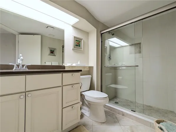 a bathroom with a shower sink vanity and toilet