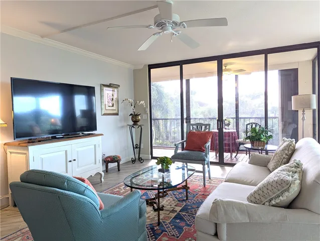 a living room with furniture a floor to ceiling window and a flat screen tv