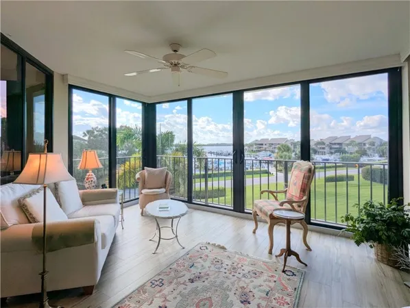 a living room with furniture and a large window with balcony view
