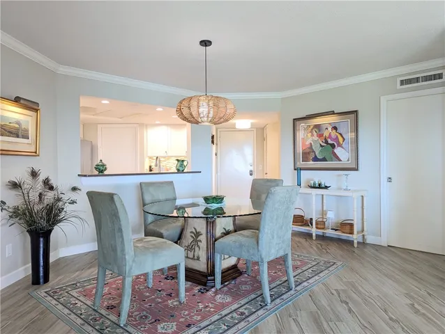 a dining room with furniture a chandelier and wooden floor