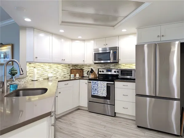 a kitchen with refrigerator a stove top oven a sink and cabinets