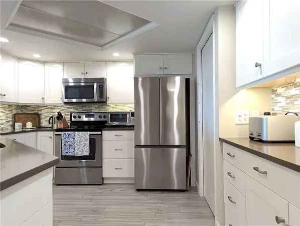 a kitchen with stainless steel appliances granite countertop a refrigerator a stove a sink and a microwave