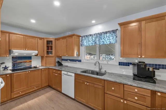 a kitchen with a sink a counter top space cabinets and stainless steel appliances