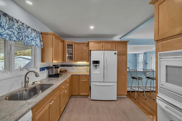 a kitchen with granite countertop a refrigerator and a sink