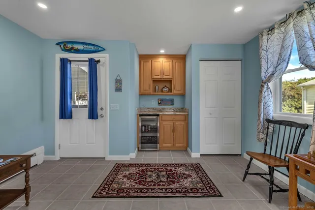 a view of a hallway to a livingroom with furniture and window