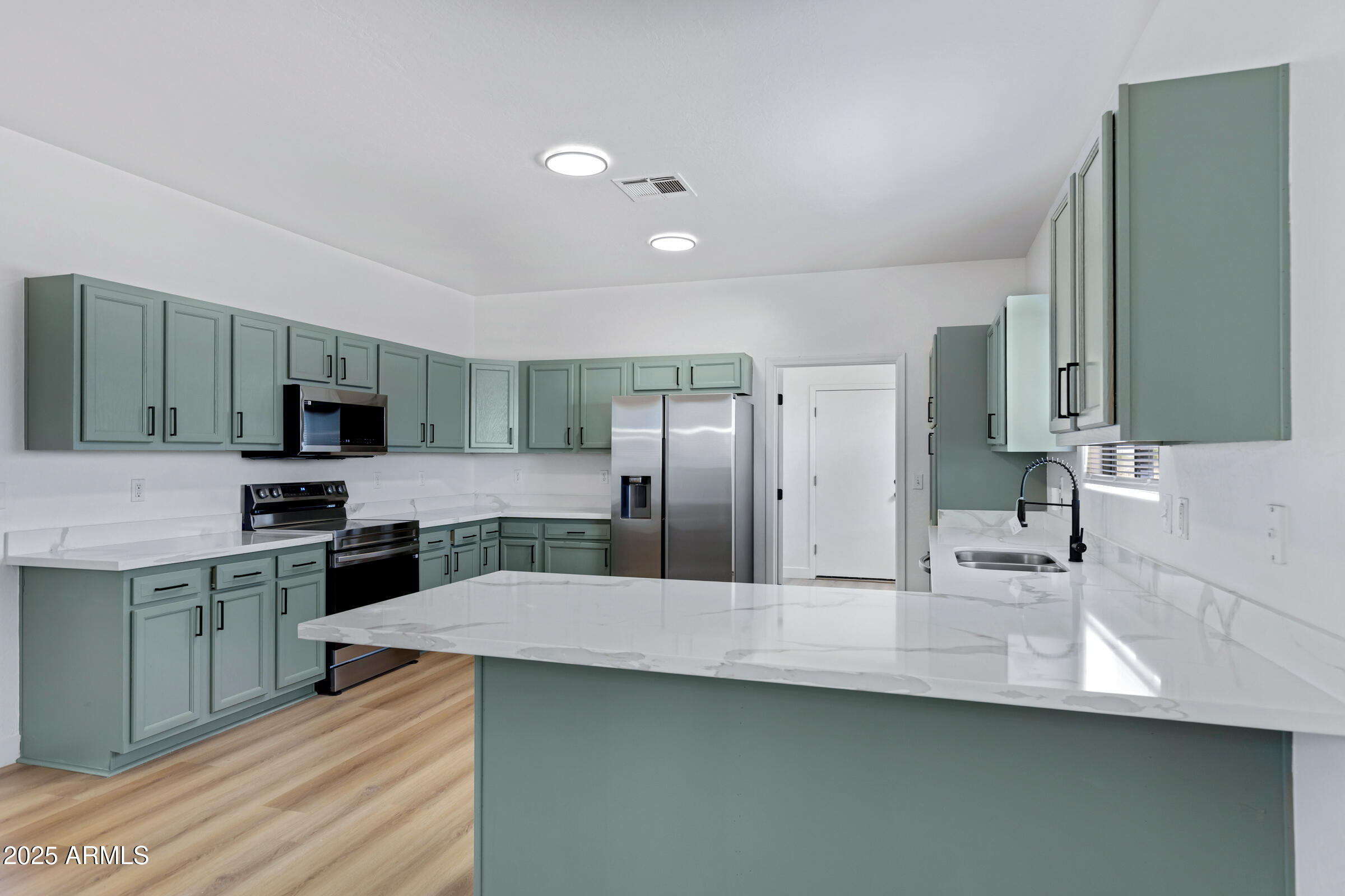 34247 West Pecan Road Tonopah, AZ 85354 - Photo 12 of 31 a kitchen with stainless steel appliances a sink counter space and cabinets