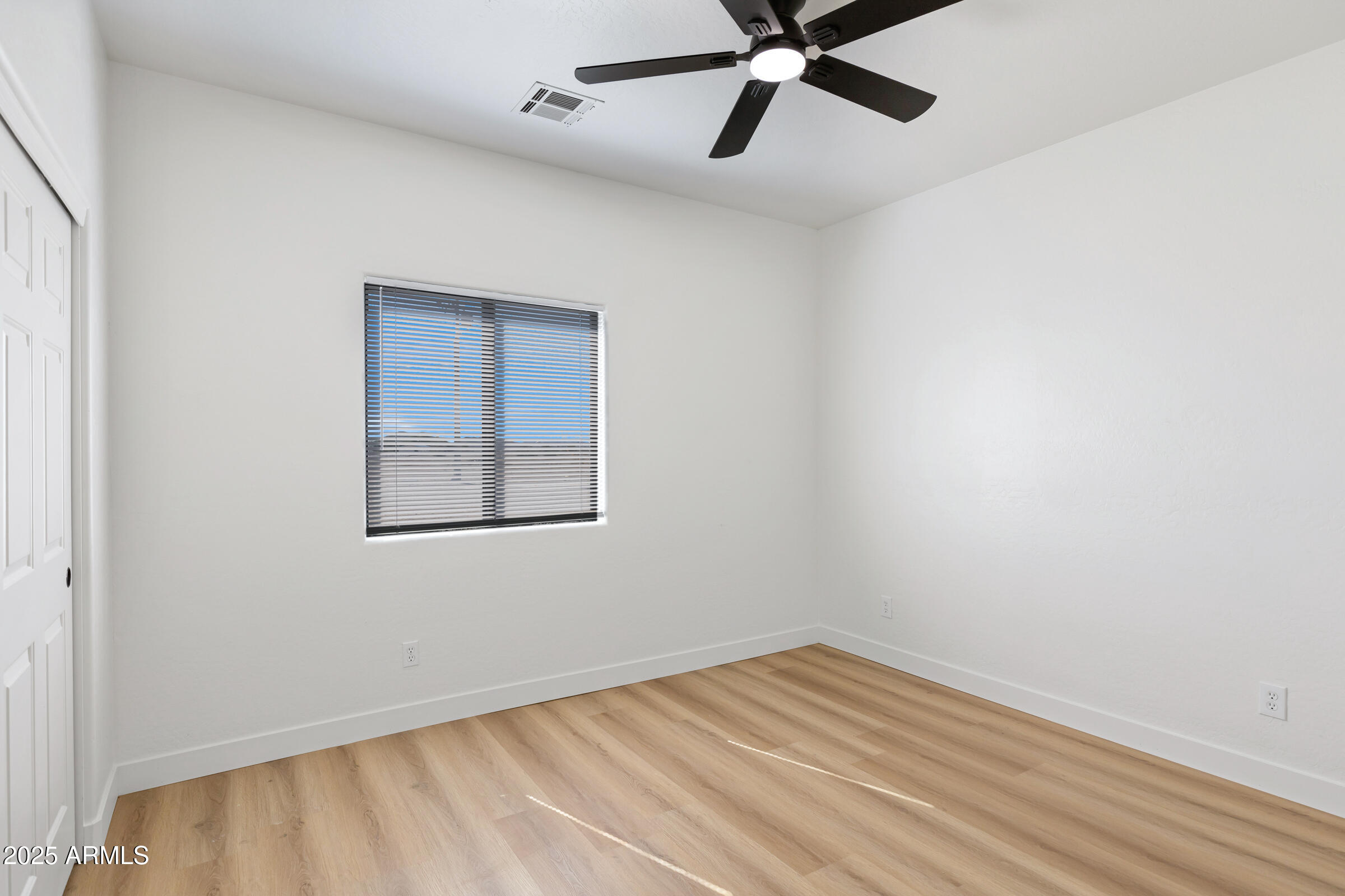 34247 West Pecan Road Tonopah, AZ 85354 - Photo 18 of 31 a view of an empty room with wooden floor and a ceiling fan