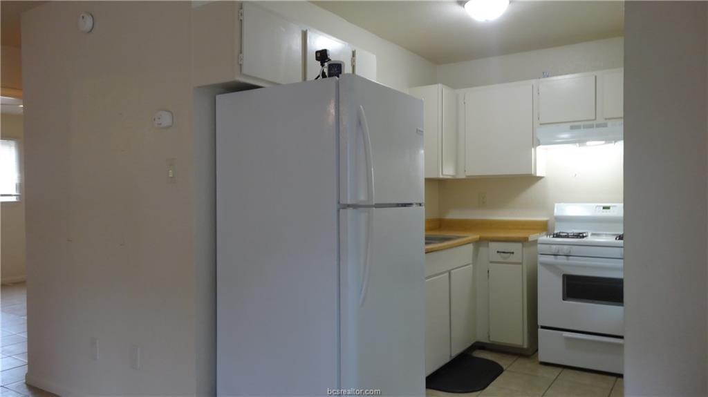 510 Avondale Avenue, Unit 14 Bryan, TX 77802 - Photo 6 of 13 a kitchen with a refrigerator and a stove top oven
