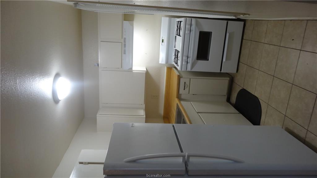510 Avondale Avenue, Unit 14 Bryan, TX 77802 - Photo 7 of 13 a kitchen with a stove and a refrigerator