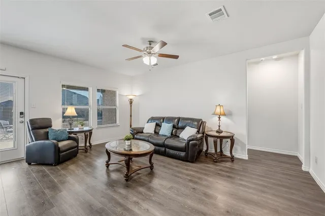 a living room with furniture and a wooden floor