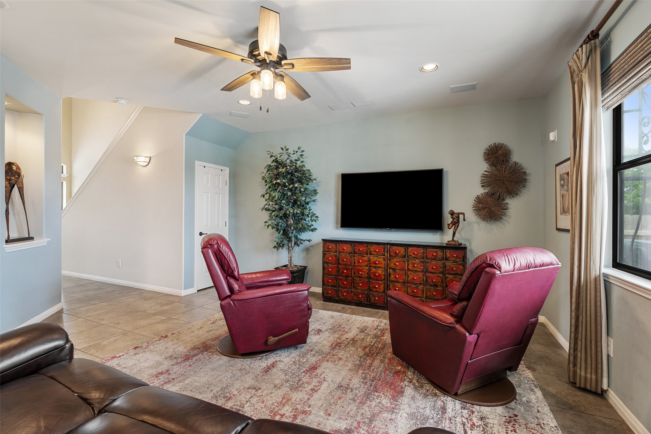 6006 Seville Drive Austin, TX 78724 - Photo 12 of 38 a living room with furniture a flat screen tv and potted plant