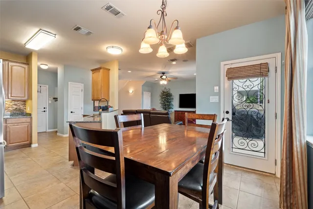 a view of a dining room with furniture a chandelier and a window