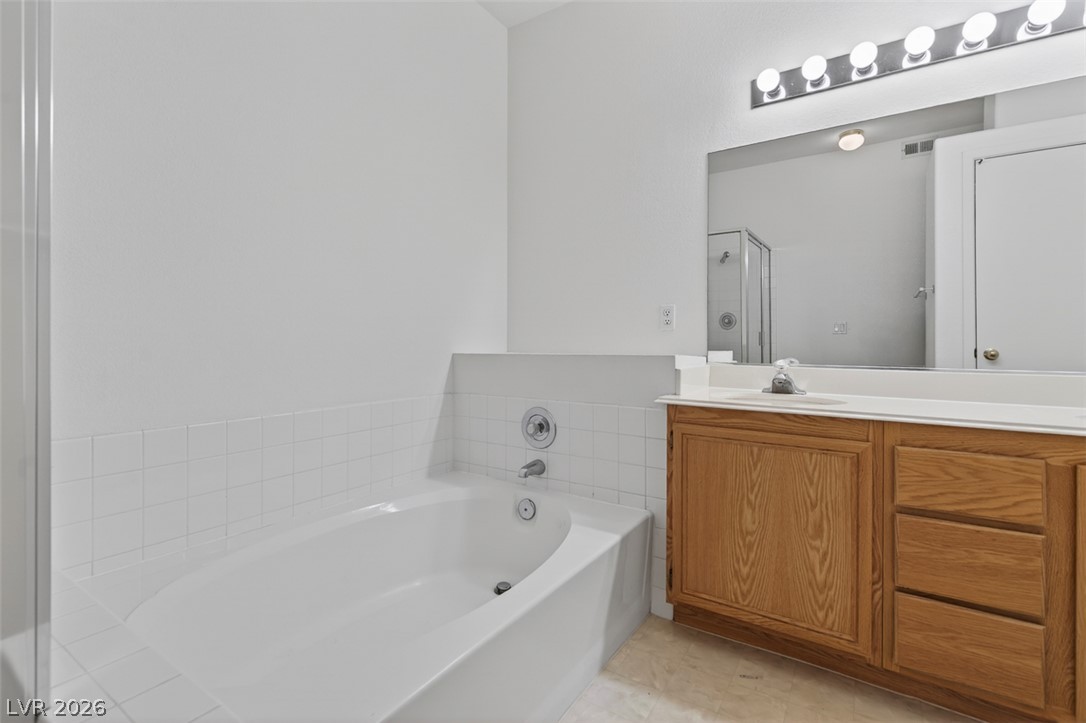 2201 Ramsgate Drive, Unit 1011 Henderson, NV 89074 - Photo 23 of 40 Indulge in relaxation with this inviting soaking tub, complemented by a spacious vanity and reflective mirror.