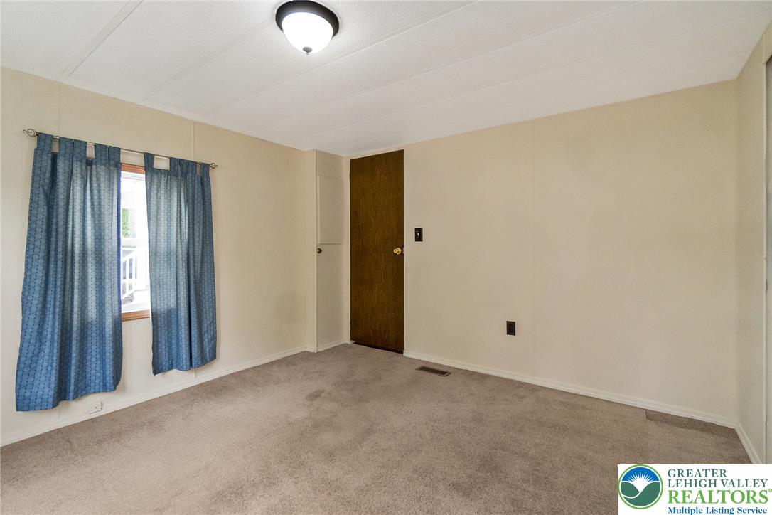 8721 Turkey Ridge Road Breinigsville, PA 18031 - Photo 26 of 30 A quiet bedroom offers soft carpeting and wood-framed window openings.