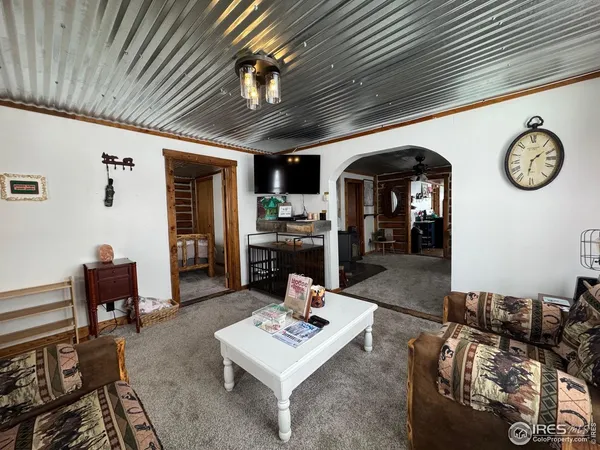 a living room with furniture a clock on wall and a table