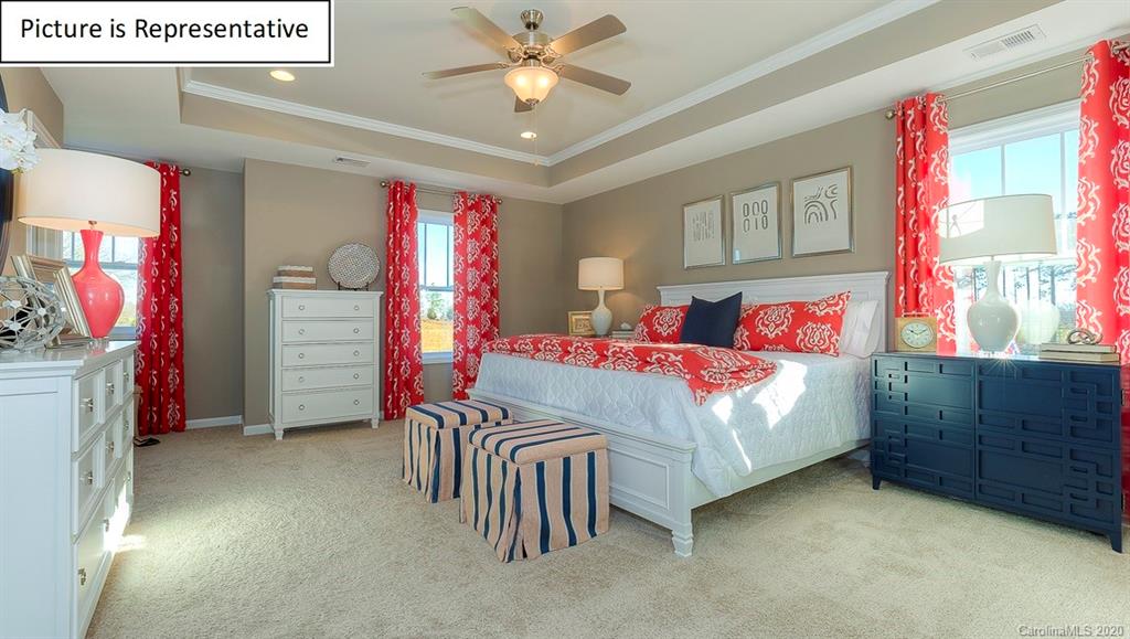 8007 Oakmere Road Waxhaw, NC 28173 - Photo 22 of 40 a bedroom with a bed and a chandelier