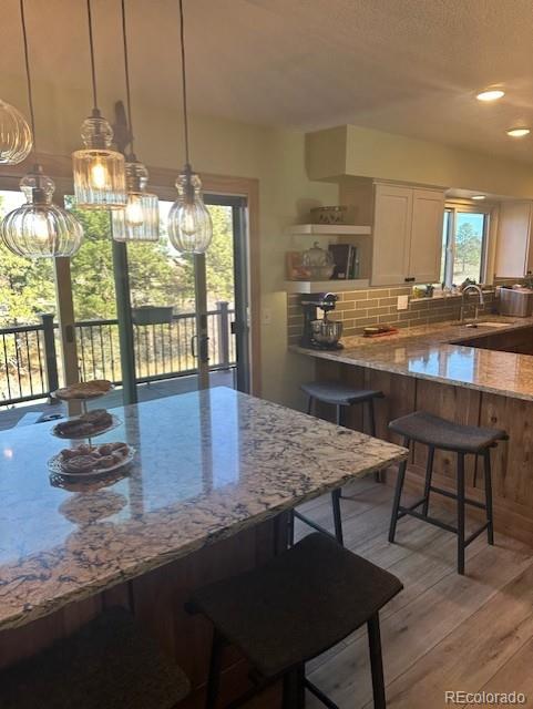 8865 Thunderbird Road Parker, CO 80134 - Photo 14 of 33 a kitchen with stainless steel appliances granite countertop a stove a sink a dining table and chairs with wooden floor