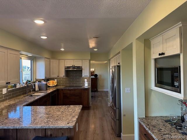 8865 Thunderbird Road Parker, CO 80134 - Photo 8 of 33 a kitchen with stainless steel appliances granite countertop a sink refrigerator and cabinets