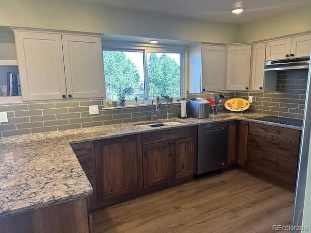 8865 Thunderbird Road Parker, CO 80134 - Photo 9 of 33 a kitchen with granite countertop wooden cabinets a sink and a window