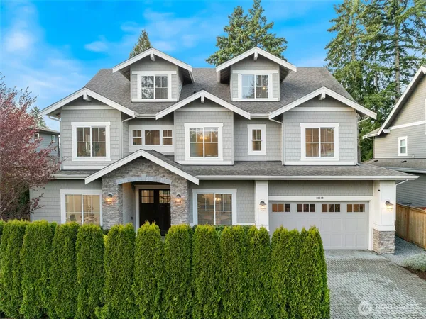 a front view of a house with a yard and trees
