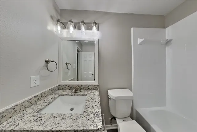 a bathroom with a sink a toilet and mirror