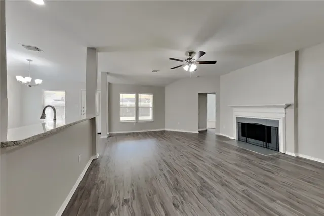 a view of a kitchen with a sink a ceiling fan and wooden floor