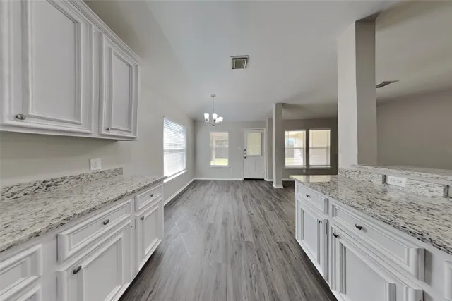 a kitchen with granite countertop a sink stove and cabinets