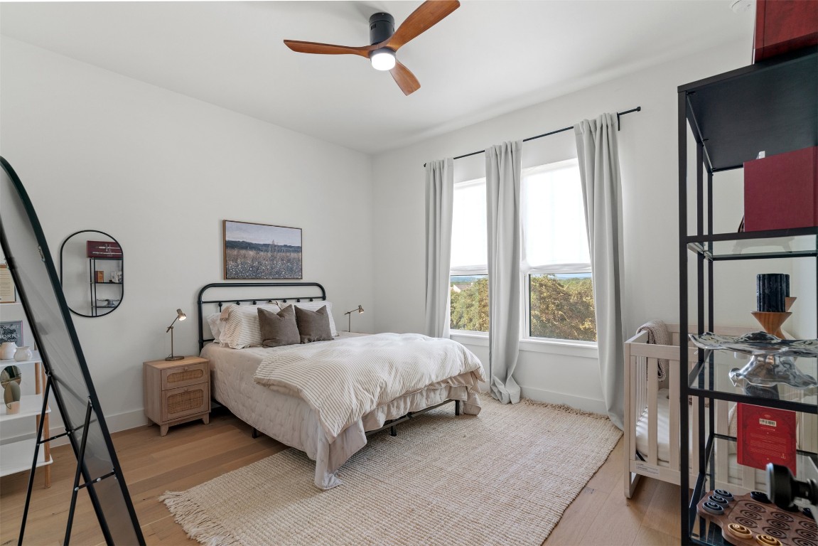 330 Kendall Road Spicewood, TX 78669 - Photo 21 of 32 a bedroom with a bed a table and flat screen tv