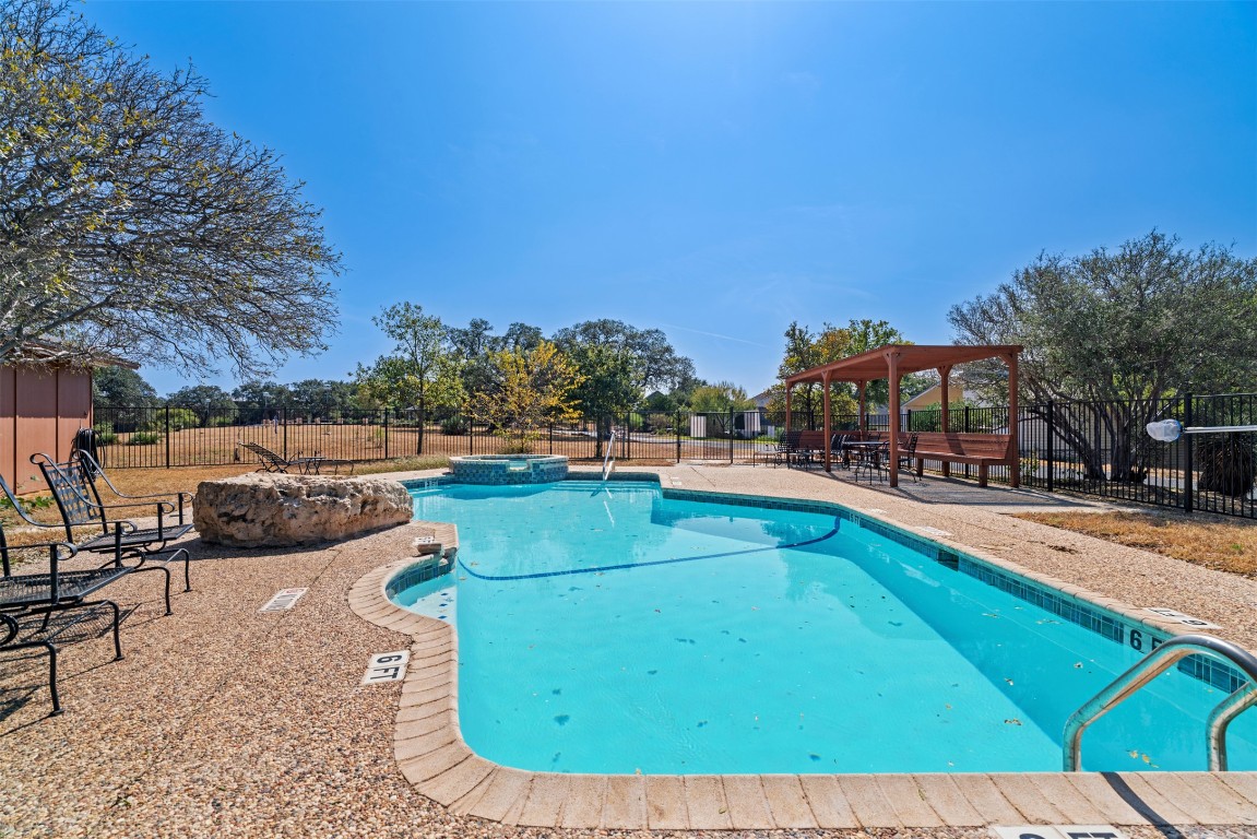 330 Kendall Road Spicewood, TX 78669 - Photo 25 of 32 a view of a swimming pool with a lounge chair