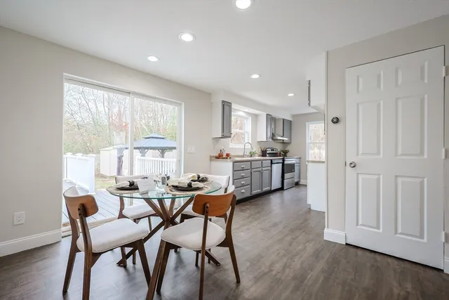 a room with stainless steel appliances kitchen island granite countertop furniture and a wooden floor
