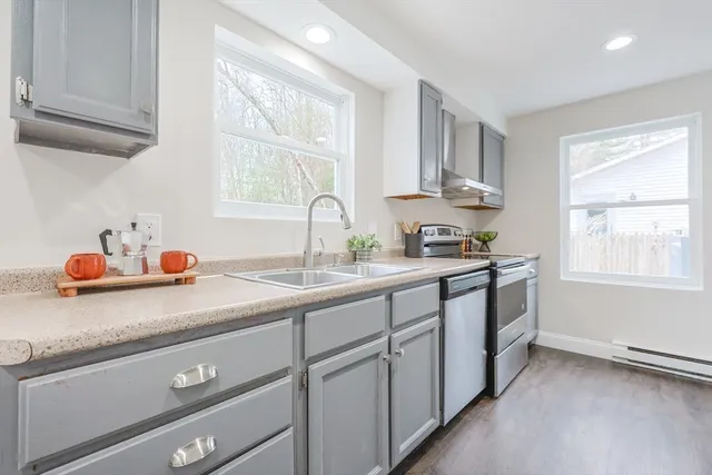 a kitchen with white cabinets and window