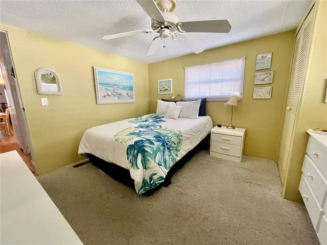 a bedroom with a bed dresser and window