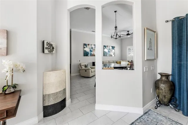 a living room with furniture kitchen view and a chandelier